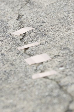 Bandages Over A Crack In The Road. clipart