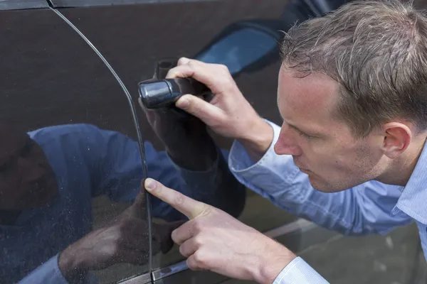 Mann kontrolliert sein Auto. — Stockfoto