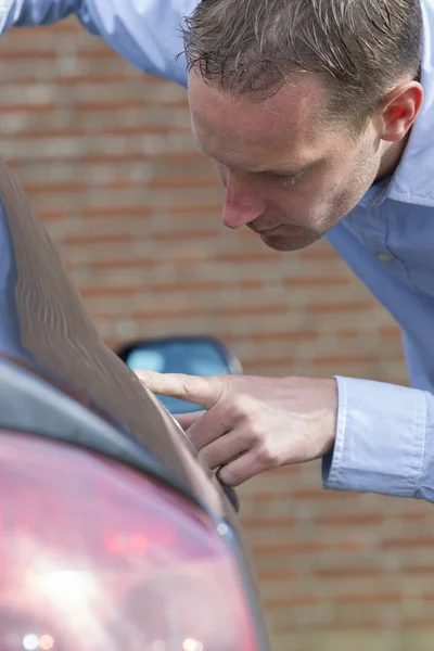 Man die zijn auto controleert. — Stockfoto