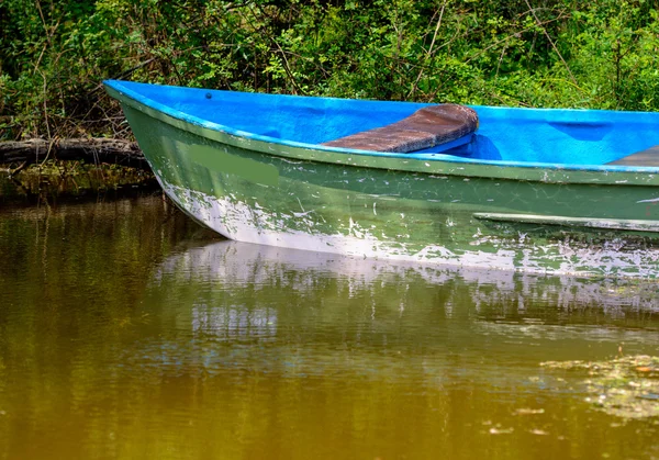 La moitié du bateau en bois dans un étang — Photo