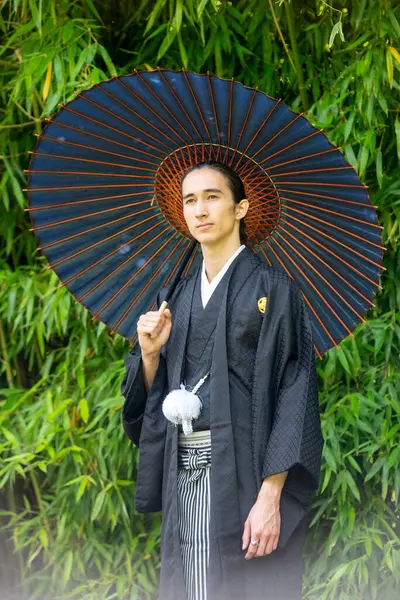 Portret Młodego Mężczyzny Ubranego Kimono Trzymającego Parasol Parku — Zdjęcie stockowe