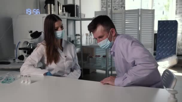 Lekarz w masce medycznej i rękawiczkach przygotowuje ampułkostrzykawkę do wstrzyknięcia, zdejmując nasadkę — Wideo stockowe