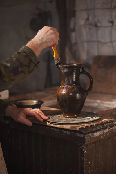 La olla dorada está cubierta con aceite usando un cepillo. Secretos de producción —  Fotos de Stock