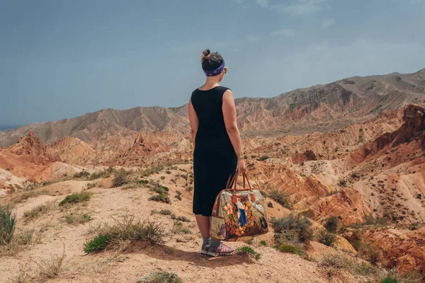 Elinde çanta olan bir kız güzel bir kanyonun arka planında duruyor. — Stok fotoğraf