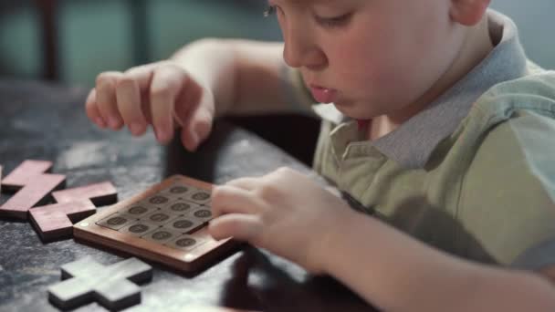 Das Kind sammelt fleißig ein Puzzle. Das Konzept von Entwicklung und Bildung — Stockvideo