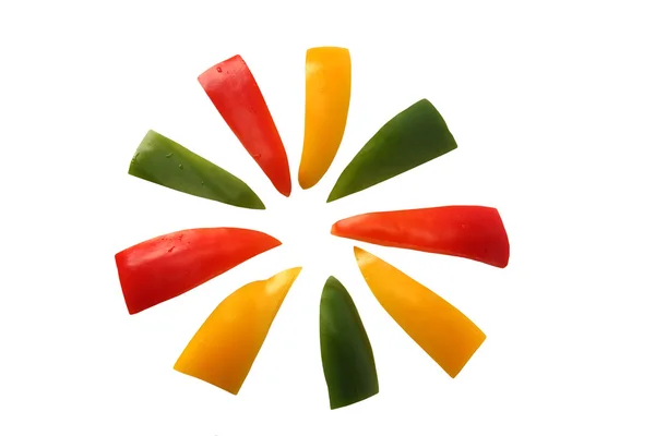 Pimienta roja, amarilla y verde en rodajas como una flor sobre un respaldo blanco —  Fotos de Stock