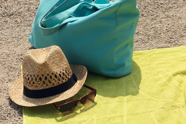 Hatt, strandväska och glasen på mattan — Stockfoto