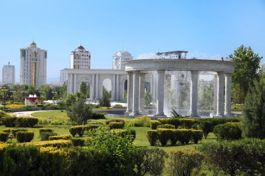 Fıskiye kompleksi ile genç bir parkın arkasında modern apartamentes.