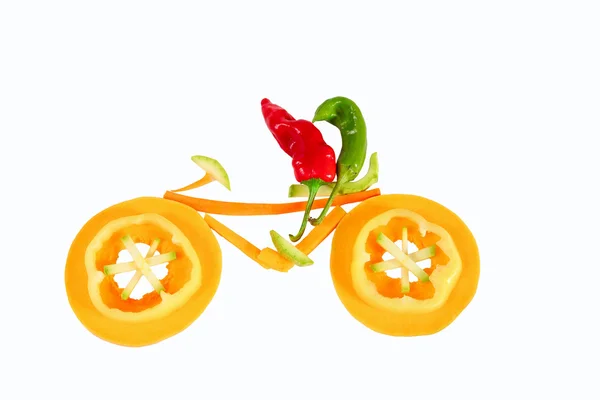 Healthy eating. Two little funny peppers on bicycle. — Stock Photo, Image