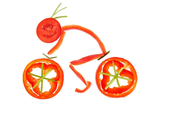 Healthy eating. Funny little man of the pepper slices on a bicyc — Stock Photo, Image