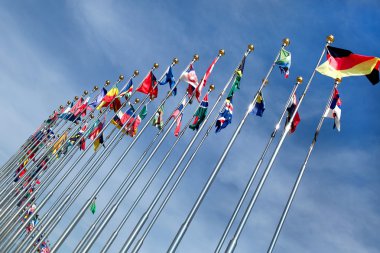 Different countries flags united together against blue sky clipart
