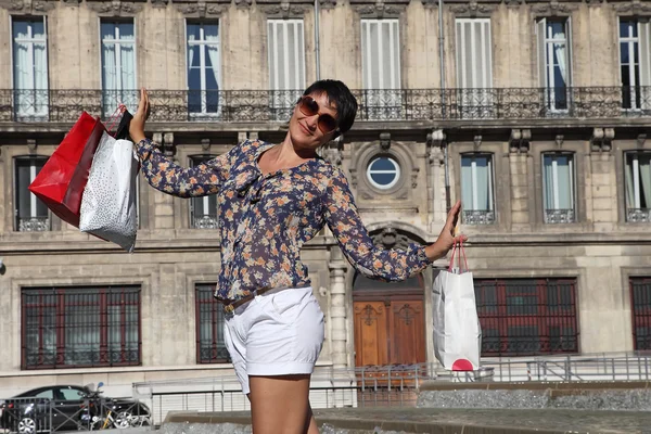 Mujeres felices con bolsas de compras caminando por la ciudad — Foto de Stock