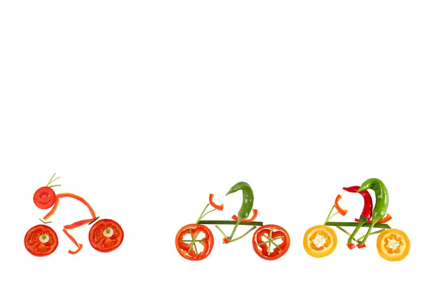 Healthy eating. Four little funny peppers on bicycles. — Stock Photo, Image