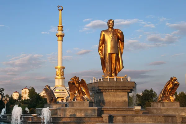 Monumen van Nijazov en boog van onafhankelijkheid in de zonsondergang. Ashkhabad — Stockfoto