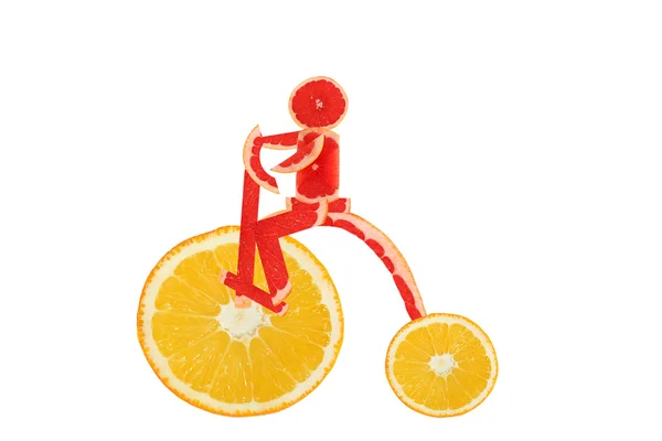 Alimentación saludable. Bicicleta vintage divertida hecha de las rebanadas de naranja con hombrecito — Foto de Stock