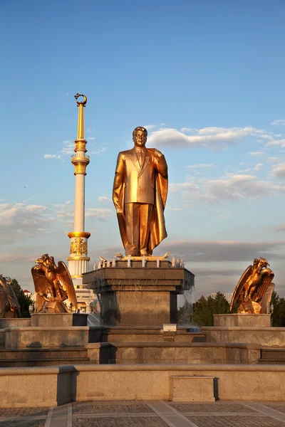 Monumen van Nijazov en boog van onafhankelijkheid in de zonsondergang. Ashkhabad — Stockfoto