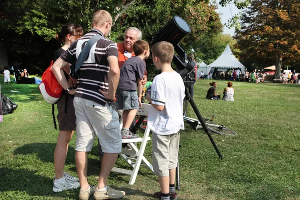 Семья стоит рядом с телескопом и слушает объяснения . — стоковое фото
