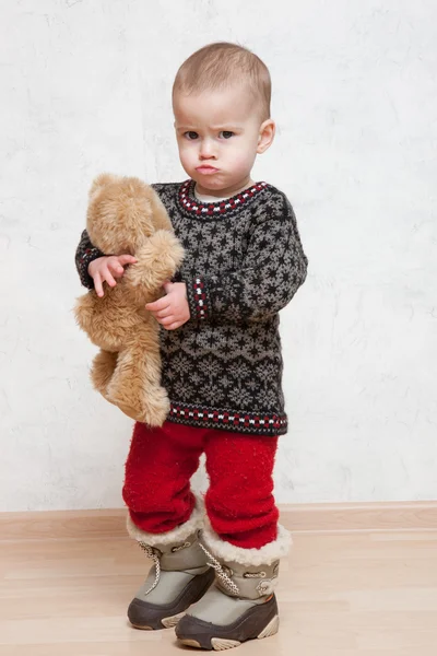 Ребёнок в зимней одежде с игрушкой — стоковое фото