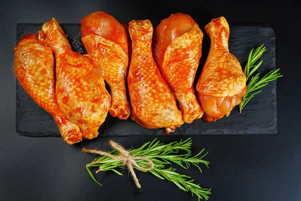 Kényelmi élelmiszer, előző.Nyers pácolt csirkeláb fűszerekkel a főzéshez BBQ sötét háttér. Felülnézet.Másolja a helyet. — Stock Fotó