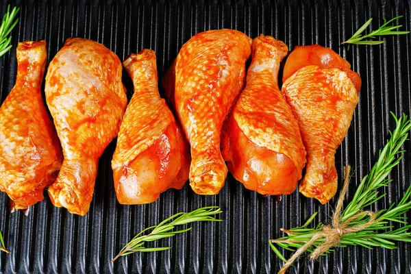 Convenience food, precooked.Raw Marinated chicken meat legs with spices for cooking for BBQ dark background. Top view.