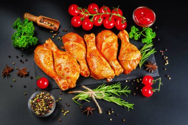 Uygun yemek, önceden pişirilmiş. Baharatlı çiğ tavuk eti bacağı ve barbekü koyu arkaplan için pişirme. Üst görünüm. Boşluğu kopyala.