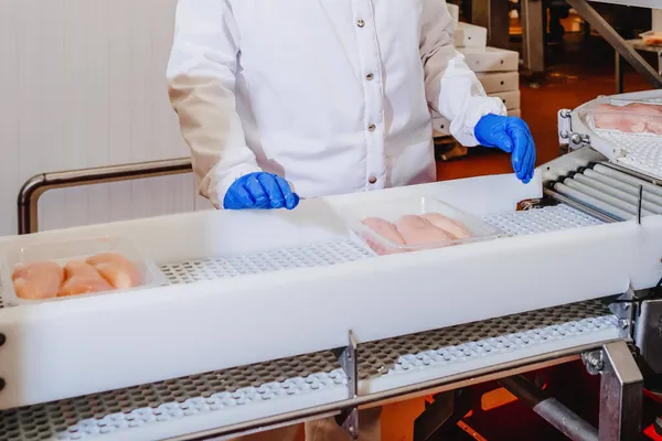 Línea de producción automatizada con envasado y corte de carne en la moderna fábrica de alimentos.Equipo de procesamiento de carne. — Foto de Stock