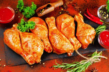 Uygun yemek, önceden pişirilmiş. Baharatlı çiğ tavuk eti bacağı ve barbekü koyu arkaplan için pişirme. Üst görünüm.