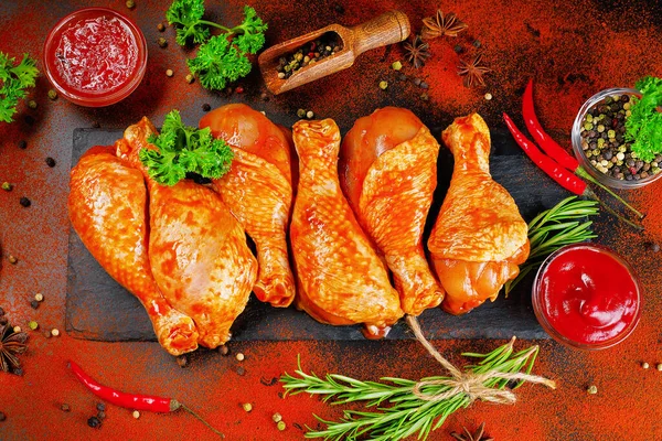 Uygun yemek, önceden pişirilmiş. Baharatlı çiğ tavuk eti bacağı ve barbekü koyu arkaplan için pişirme. Üst görünüm. Boşluğu kopyala.