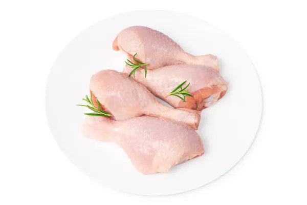 Pernas de frango frescas close-up isolade.Top vista de uma perna de frango inteiro cru de quatro peças em uma placa branca em um fundo isolado branco. — Fotografia de Stock