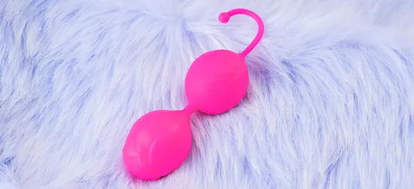 Pink vaginal balls,pink background.Double vaginal balls. Strengthening the intimate muscles of the vagina.dildo vibrator. Strengthening the intimate muscles of the vagina.