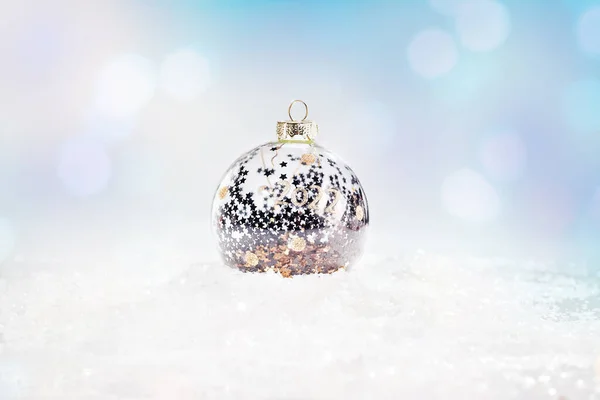 Glittering, sfondo lucido.Natale, inverno, nuovo anno concettuale.copia spazio.Sfondo inverno.Natale e Capodanno vacanza, bokeh, luce.Brillante, palla di Natale in vetro argento su neve su uno sfondo leggero. — Foto Stock