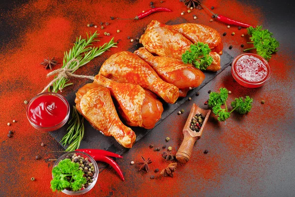 Convenience food, precooked.Raw Marinated chicken meat legs with spices for cooking for BBQ dark background. Top view.Copy space.