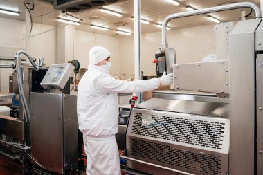 Modern gıda fabrikasında et paketleme ve kesme ile otomatikleştirilmiş üretim hattı. Et işleme ekipmanları.