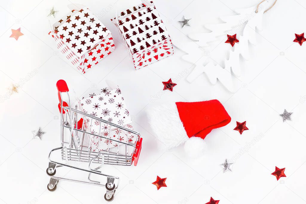 Christmas and New Year background.Supermarket trolley with New Years gifts on a light background.