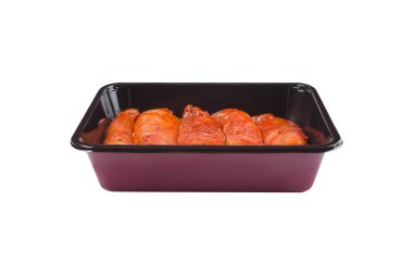 Market için bir tepside kırmızı soslu çiğ tavuk filetosu, beyaz izole bir arka planda kızartma tepsisi, kopyalama alanı. Taze marine edilmiş tavuk eti. Fırın hazır tavuk..