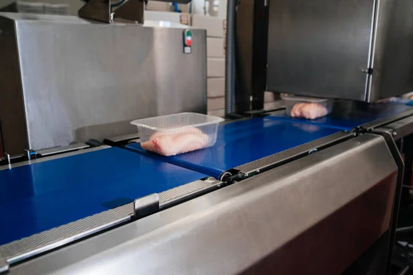 Linea di produzione automatizzata con confezionamento e taglio di carne nella moderna industria alimentare.Attrezzature per la lavorazione della carne. Linea di produzione di filetti di pollo di carne alimentare in imballaggi in plastica sul trasportatore. — Foto Stock