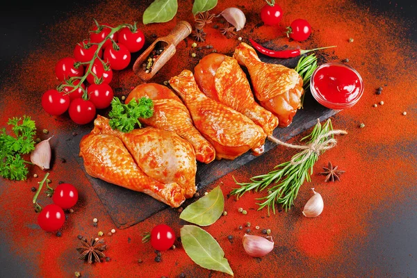 Convenience food, precooked.Raw Marinated chicken meat legs with spices for cooking for BBQ dark background. Top view.Copy space.