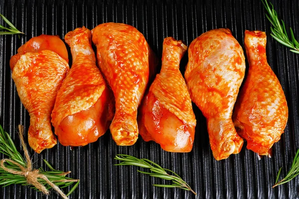 Convenience food, precooked.Raw Marinated chicken meat legs with spices for cooking for BBQ dark background. Top view.Copy space.