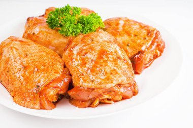 Yarı pişmiş tavuk. Kırmızı soslu tavuk butlarında terbiye edilmiş beyaz bir tabakta, izole edilmiş beyaz bir zeminde. Çiğ tavuk marine edilmiş. Ayrı nesne, boşluğu kopyala. Üst görünüm.