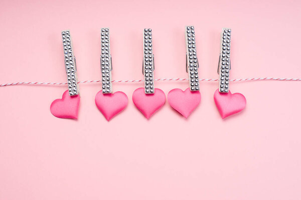 Lots of pink hearts on a light pink background. Love concept. Greeting card.Background of different colored wooden hearts