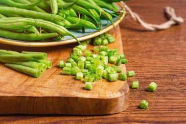 Fresh Asparagus Beans For Eating.Salad ,Wooden Background ,Spinach Salad ,Healthy Fresh Food.Healthy and fresh food.Whole and chopped fresh green beans on a cutting board.Bowl of green beans .
