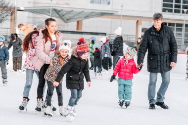 Slovakya.Bratislava.28.12.2018 Soft, Seçici odak. İnsanlar Avrupa 'daki City Park Buz Pisti' nde buz pateni yapıyor. Açık hava aktivitelerinin tadını çıkarıyorum. Bir grup genç arkadaş buz pateni pistinde buz pateni yapıyor..