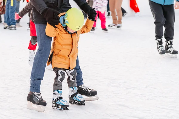 Soft,Selective focus.Activity, Adult, Child, Childhood, Daughter. Mom with baby boy 3-5 years old, learn train, ride winter city rink, ice skating.Funny moment fell on the ice skating rink. — Stock Photo, Image