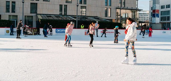 Slowakien.Bratislava.28.12.2018 .Weiche, selektive Schwerpunkt.Eislaufen auf der City Park Eisbahn in Europa. Genießen Sie winterliche Aktivitäten im Freien. Gruppe von Teenagerfreunden Schlittschuhlaufen auf einer Eisbahn. — Stockfoto