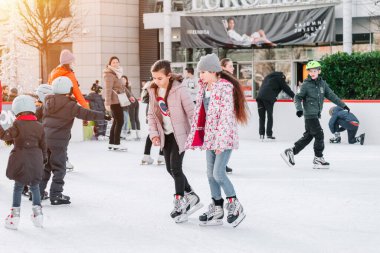 Slovakya. Bratislava.28.12.2018 Soft, Seçici Odaklanma. Bir grup genç arkadaş buz pistinde buz pateni yapıyor. Kışın açık havada eğlenmek..