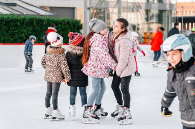 Slovakya.Bratislava.28.12.2018 Soft, Seçici odak. İnsanlar Avrupa 'daki City Park Buz Pisti' nde buz pateni yapıyor. Açık hava aktivitelerinin tadını çıkarıyorum. Bir grup genç arkadaş buz pateni pistinde buz pateni yapıyor..