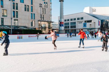 Slovakya. Bratislava.28.12.2018 Soft, Seçici Odaklanma. Bir grup genç arkadaş buz pateni pistinde buz pateni yapıyor. Kışın açık havada eğlenmek..