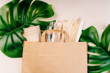 Eko-el yapımı kağıt sofra takımı, fincanlar, fast food kapları. Geri dönüşüm, çevre dostu konsept. Atılabilir eko çatal bıçak takımı, tabaklar, kaşıklar, bıçaklar, çatallar hafif bir arka planda. Yiyecek teslimatı için kağıt torba..