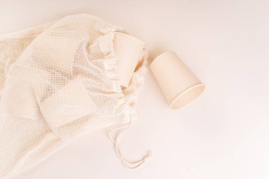 Çevre dostu bir torba içinde tek kullanımlık kağıt bardaklar. Plastik kızartma konsepti. Düz açılı. Boşluğu kopyala. Geri dönüşüm konsepti. Çevre dostu tek kullanımlık sofra takımı..