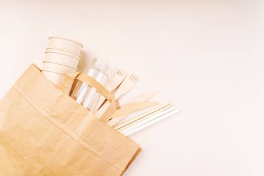 Eko-el yapımı kağıt sofra takımı, fincanlar, fast food kapları. Geri dönüşüm, çevre dostu konsept. Atılabilir eko çatal bıçak takımı, tabaklar, kaşıklar, bıçaklar, çatallar hafif bir arka planda. Yiyecek teslimatı için kağıt torba..